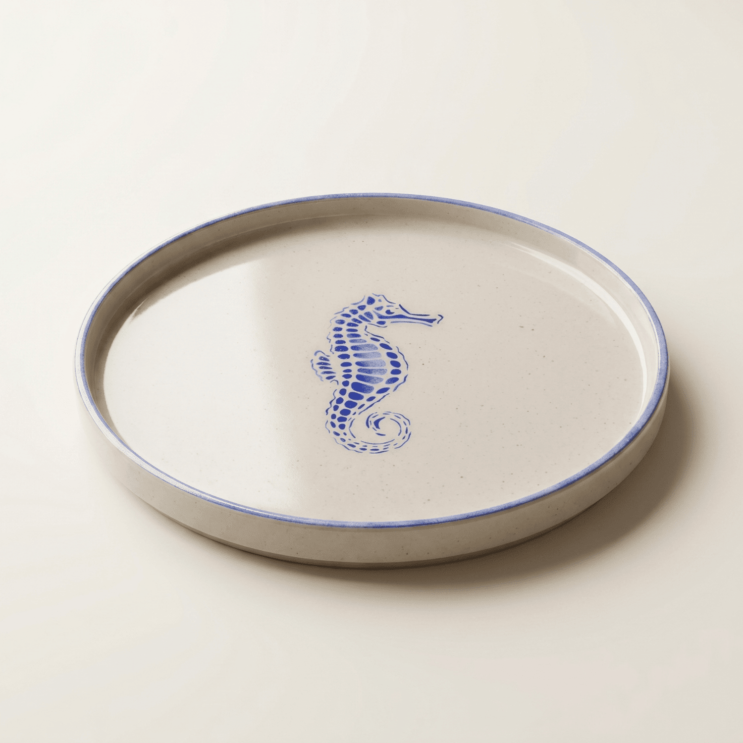 Plato decorativo artesanal con caballito de mar azul visto en ángulo