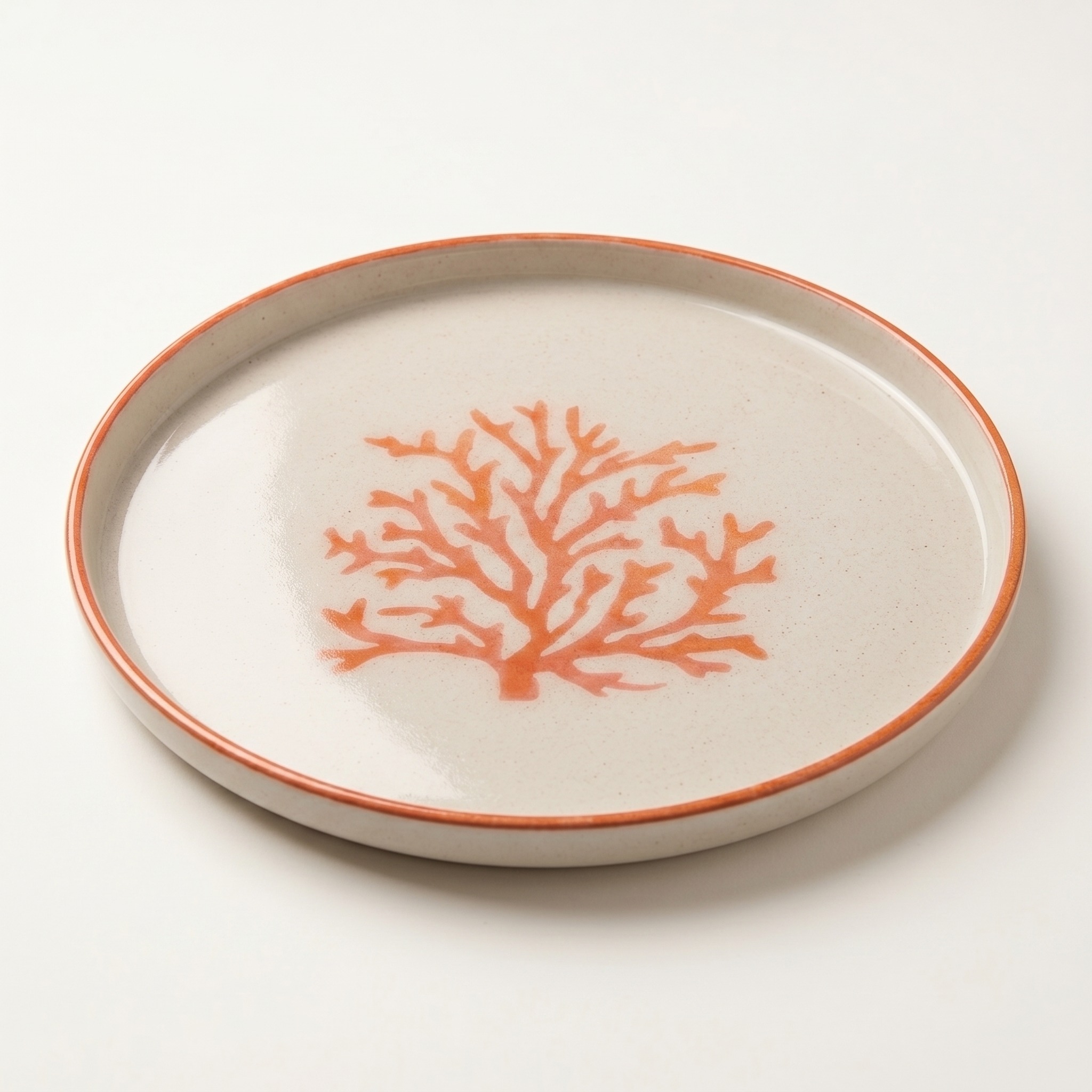 Plato decorativo artesanal con coral pintado a mano visto en ángulo