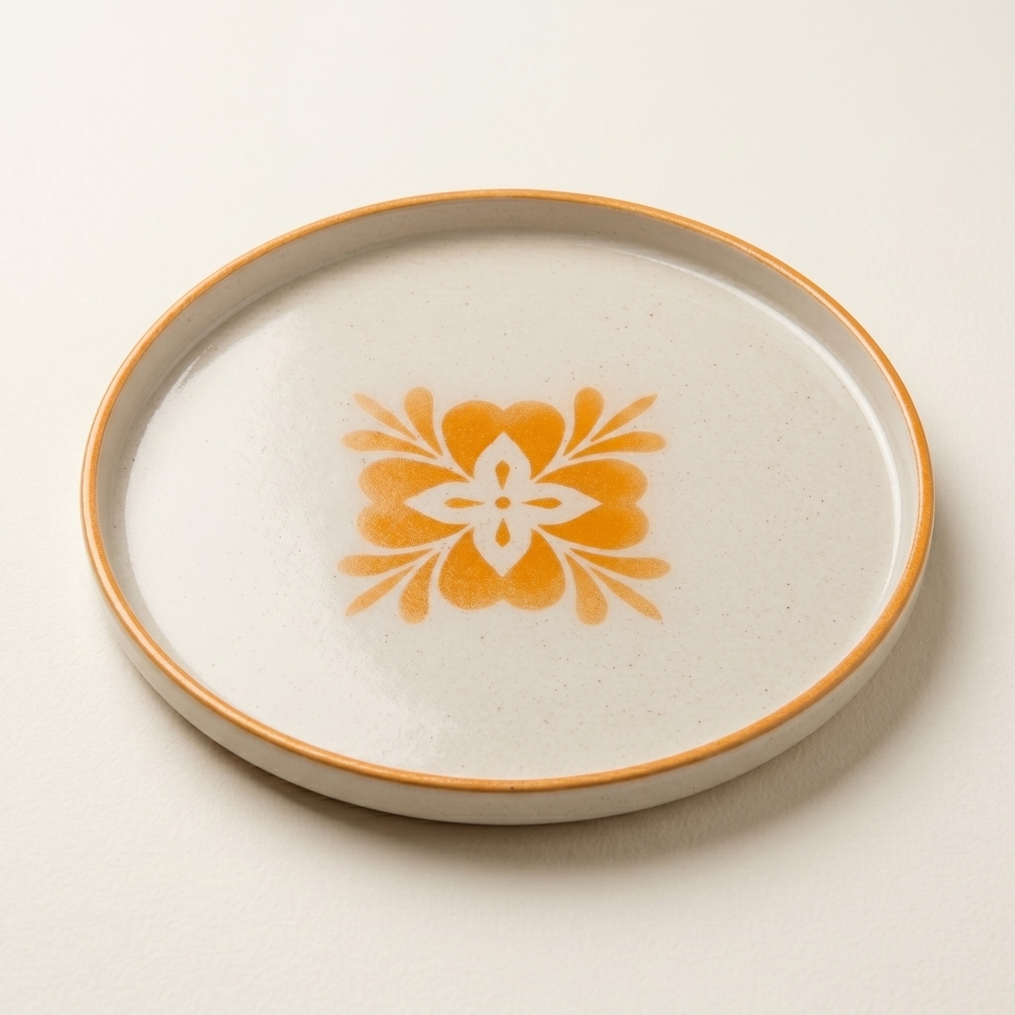 Plato decorativo artesanal con motivo floral naranja visto en ángulo