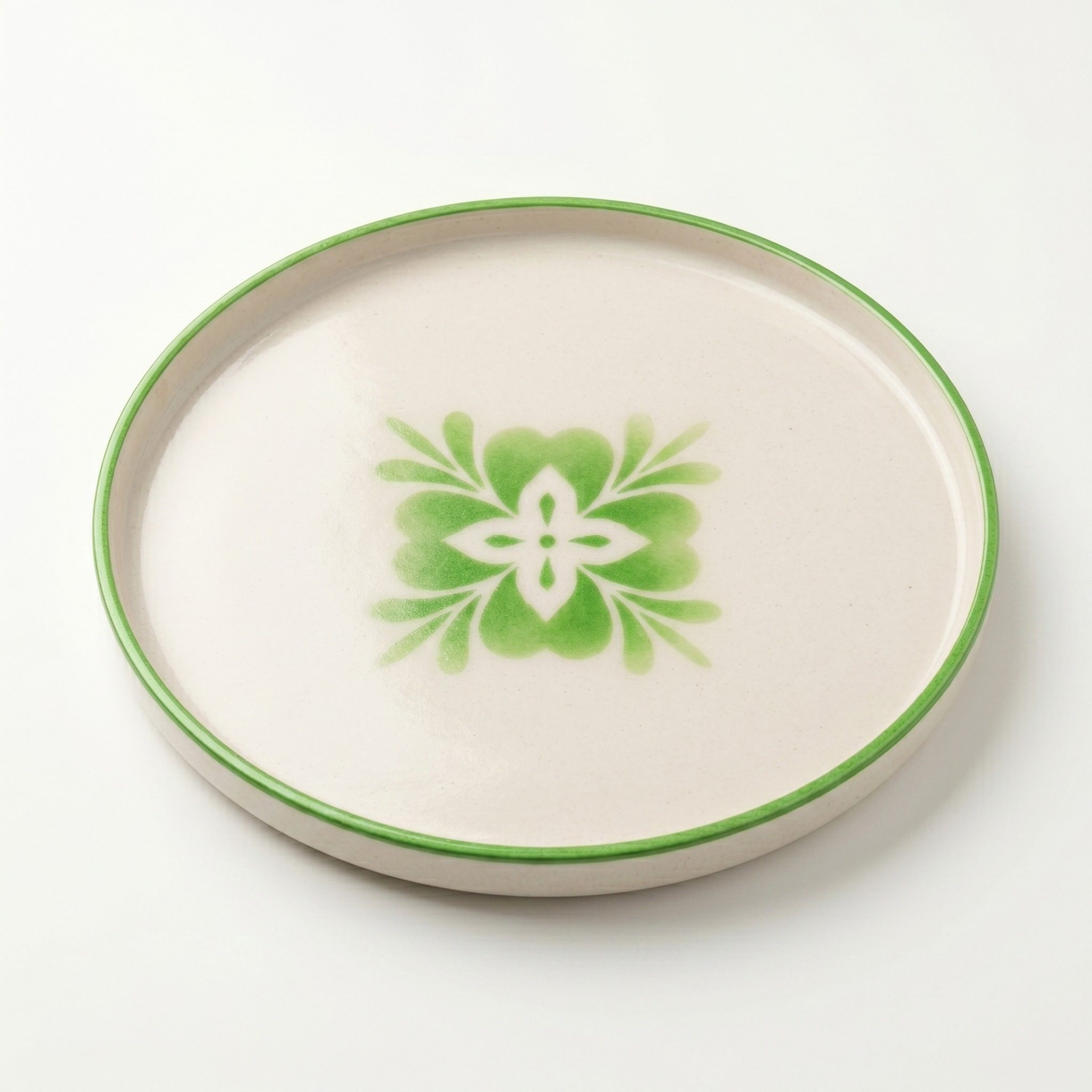 Plato decorativo artesanal con motivo floral verde visto en ángulo